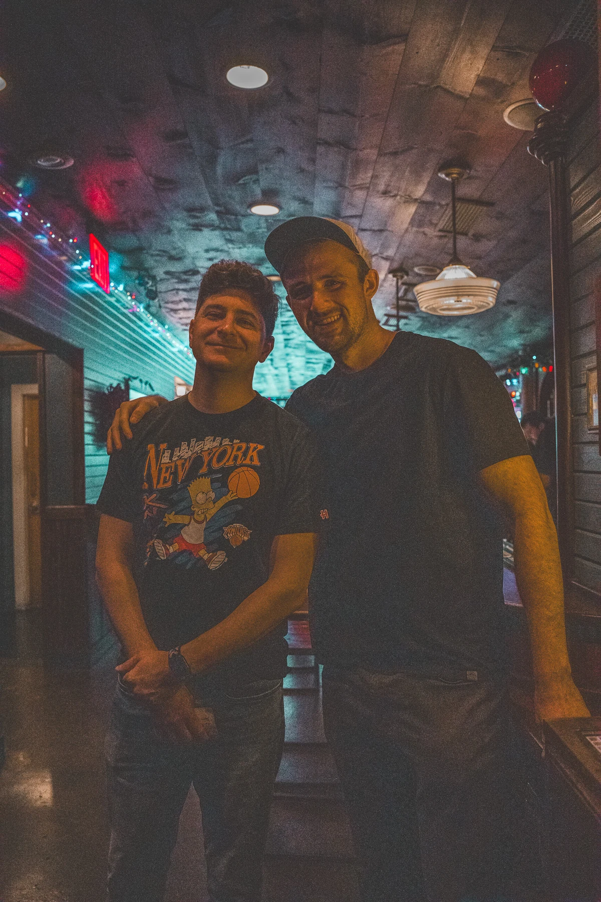Sam Frank Jr. and Ryan Beck standing together in a warmly lit venue.
